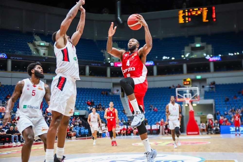 Hapoel žaidėjas meta per priešininko rankas 