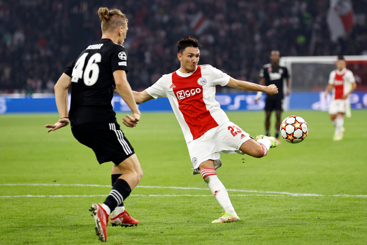 Ajax žaidėjas smugiuoja futbolo kamuolį 